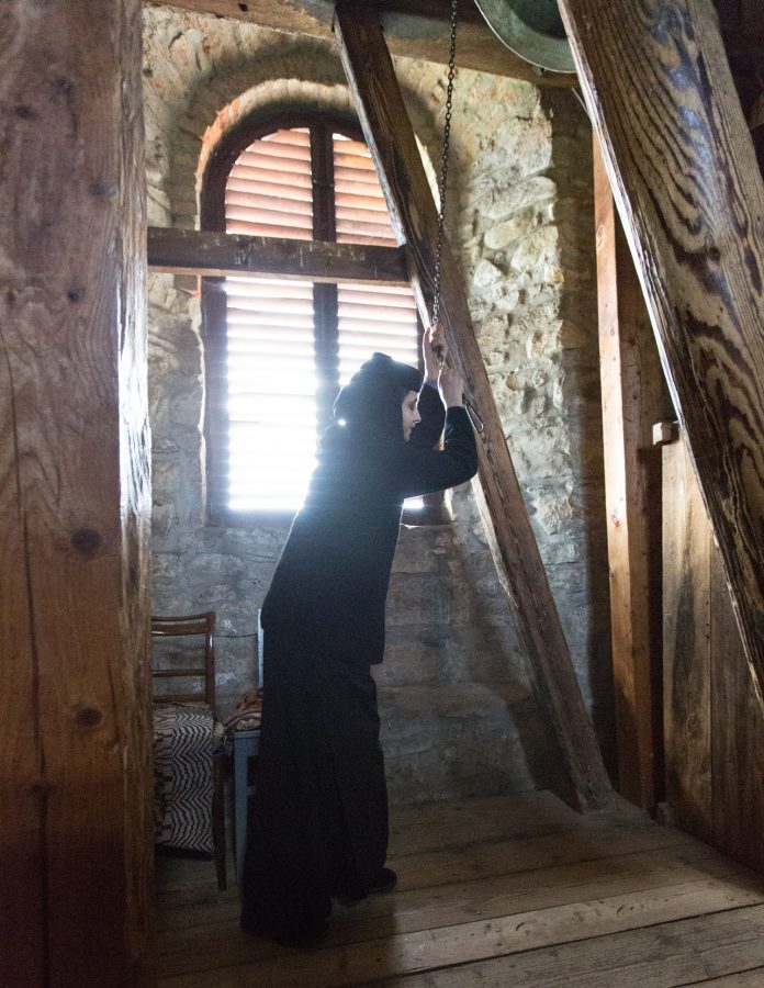 Nonne im Kloster Moldovița beim läuten einer Glocke.