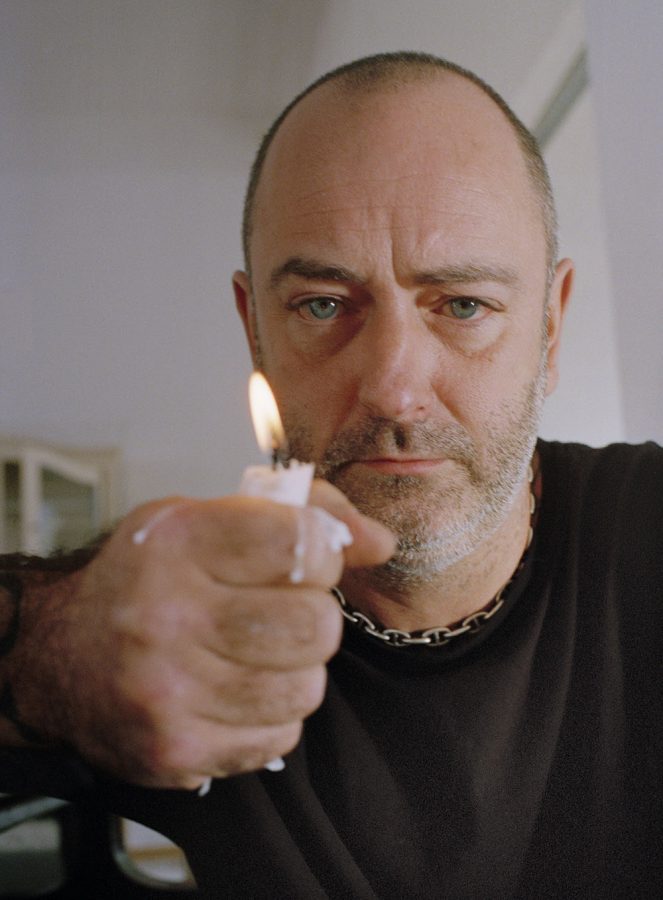 Douglas Gordon holds a burning candle in his hand.