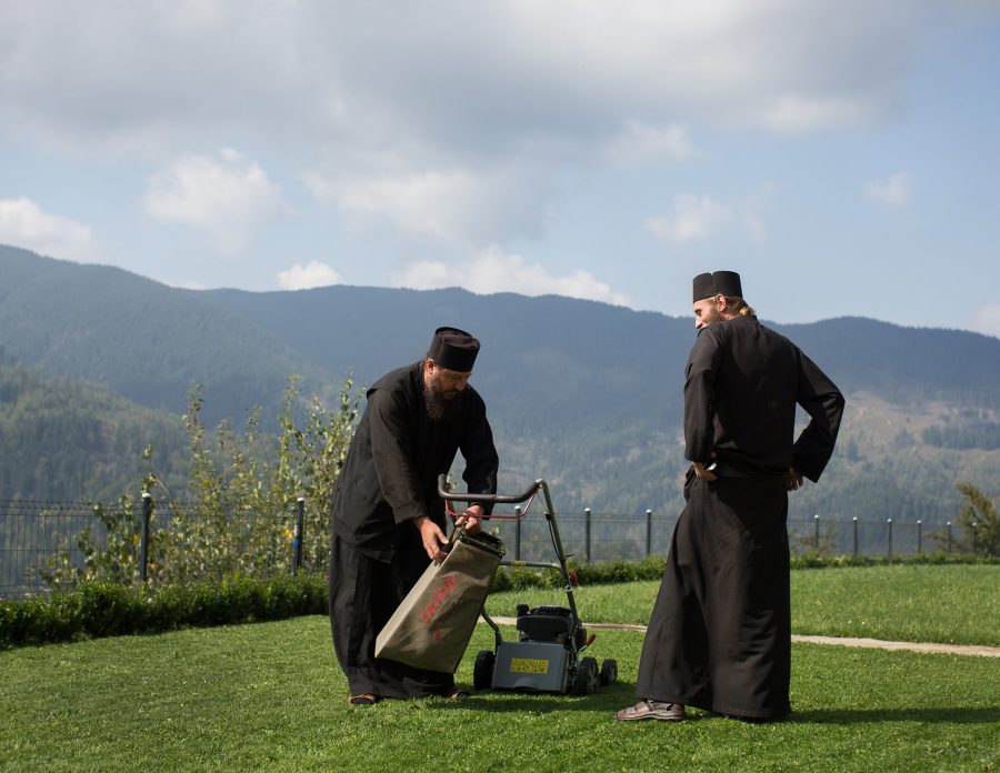 Two monks mowing lawns in the mountains of Bukovina.