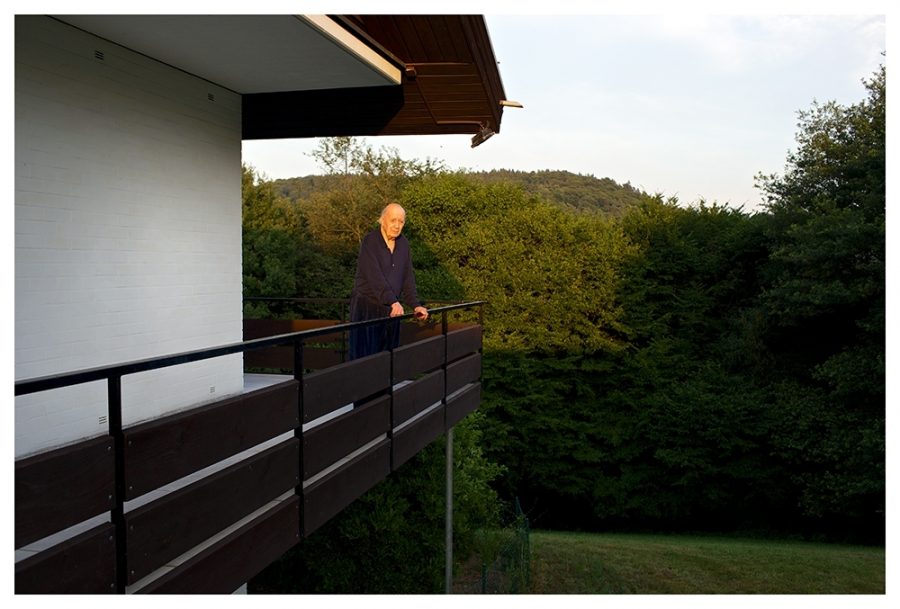 The artist Karl Otto Götz is standing on his balcony in the last evening light.