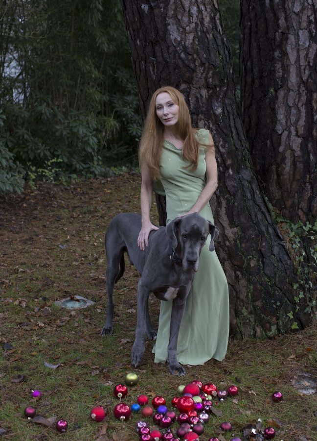 Actress Andrea Sawatzki in her garden by a tree, guarded by her Great Dane named Gustav.