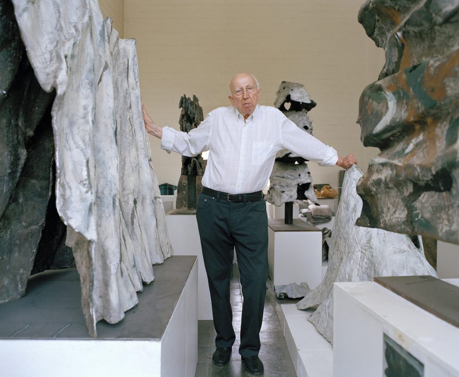 Emil Cimiotti stands between his sculptures.