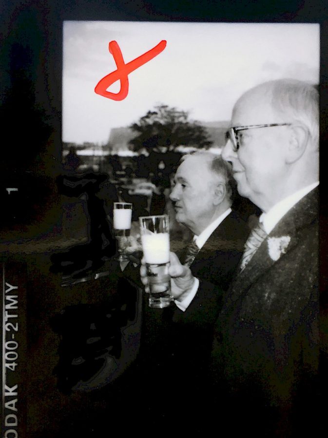 Gilbert and George hold two beer glasses in their hands.