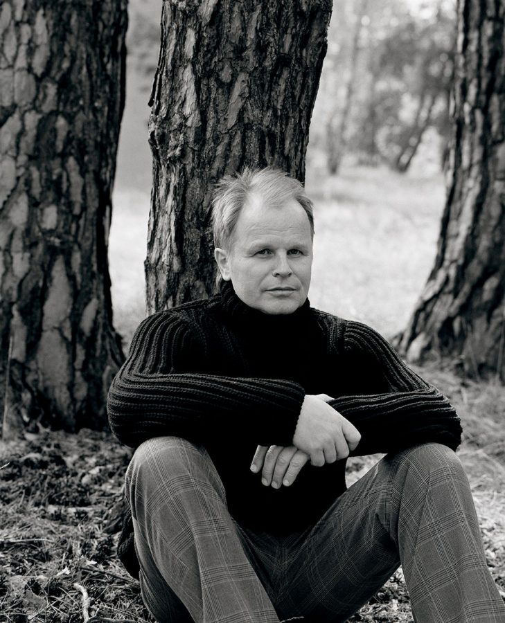 Herbert Grönemeyer sitting by trees and looking into the distance.