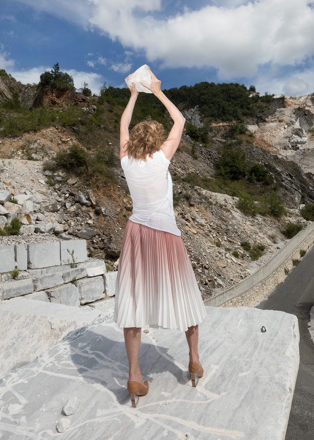 The sculptor Isa Melsheimer holds a piece of marble in both hands.
