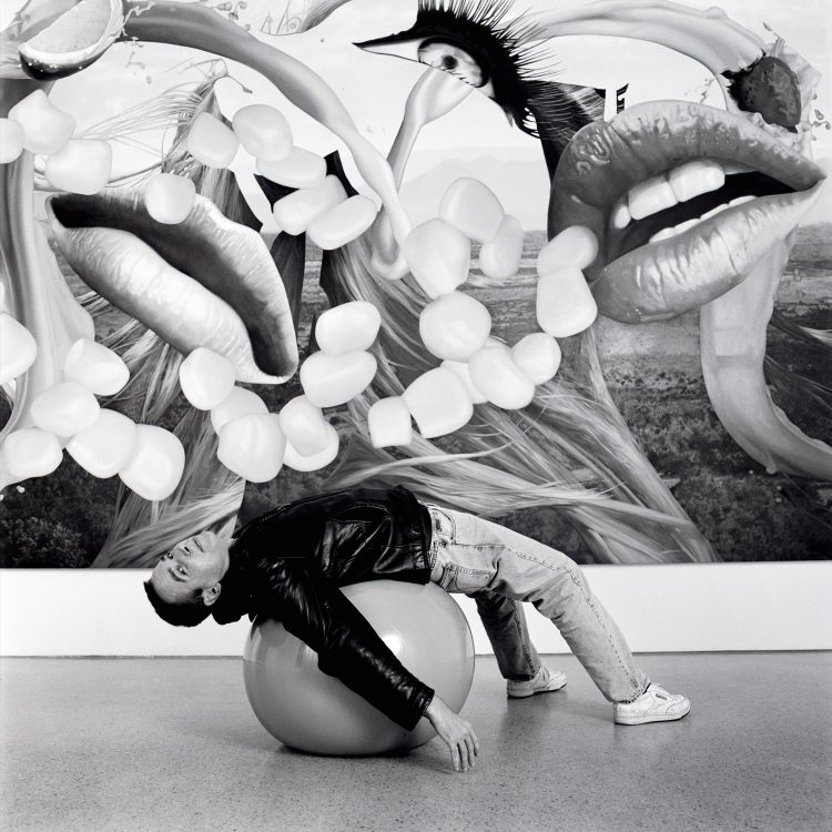 Jeff Koons lying on gymnastic ball with one of his Easyfun-Ethereal paintings.