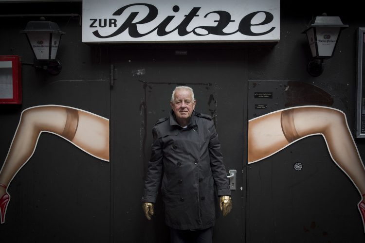 Kai Hermann in front of the Ritze in Hamburg with golden gloves.