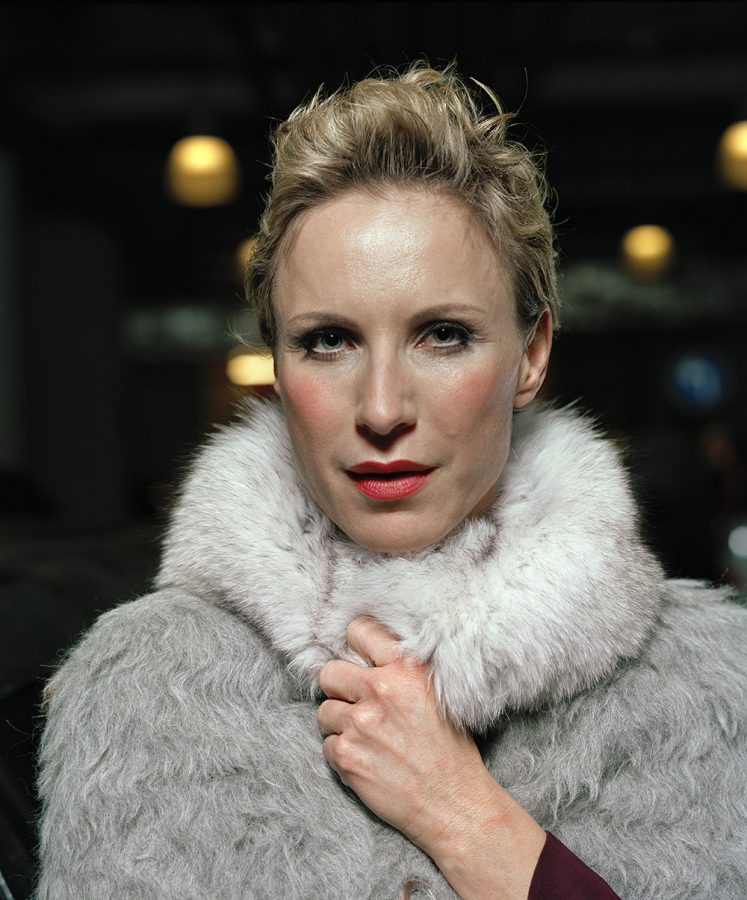 Nadja Michael wearing a white, furry coat and short, blonde hair.