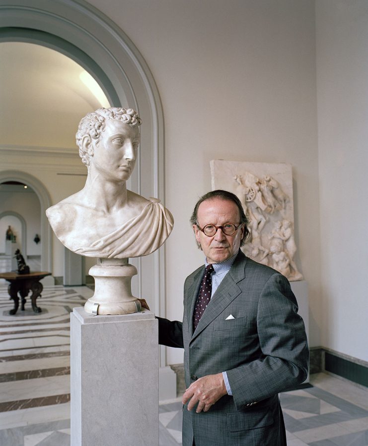 Peter-Klaus Schuster posing in a museum beside a marble bust of Baccio Bandinelli.