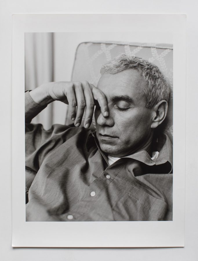 Roland Emmerich resting on a couch with his eyes closed.