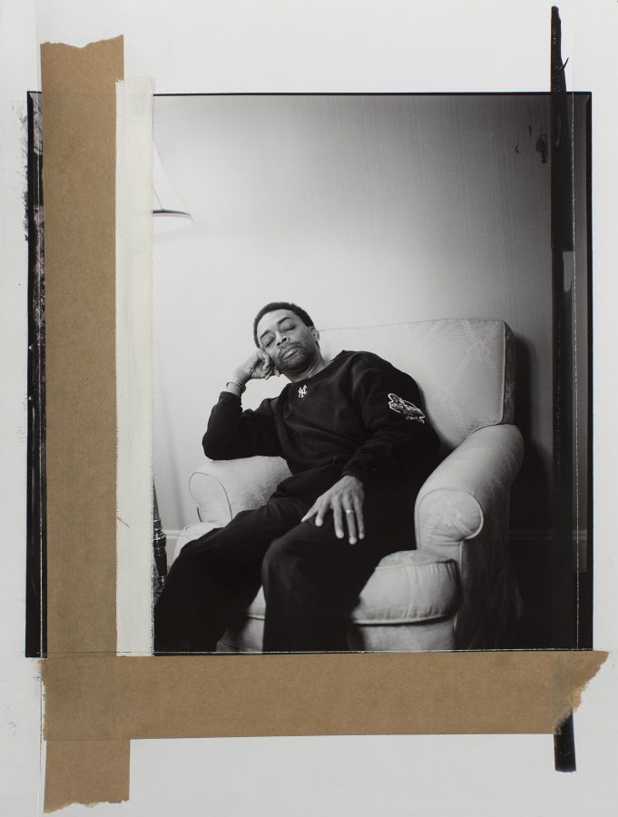 Spike Lee sitting casually on a couch resting head in his hand.