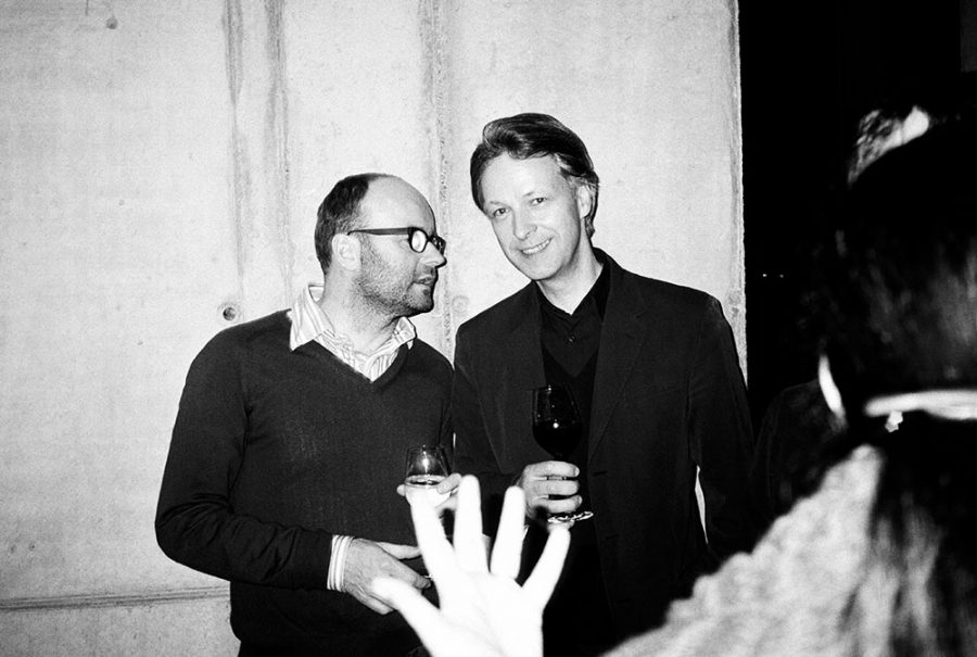 Thomas Demand talking to a smiling Andreas Slominski at a party.