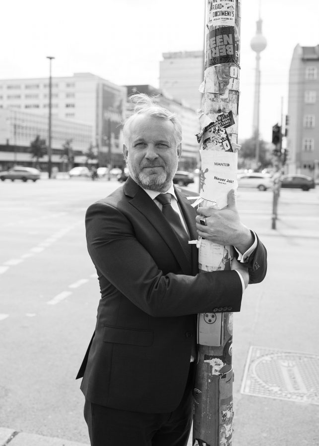 Thomas Girst hugs a pillar in Berlin Mitte.