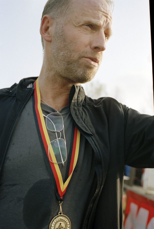 Artist Ulrik Møller wearing a gold medal on a ribbon necklace with the colours of the German flag.