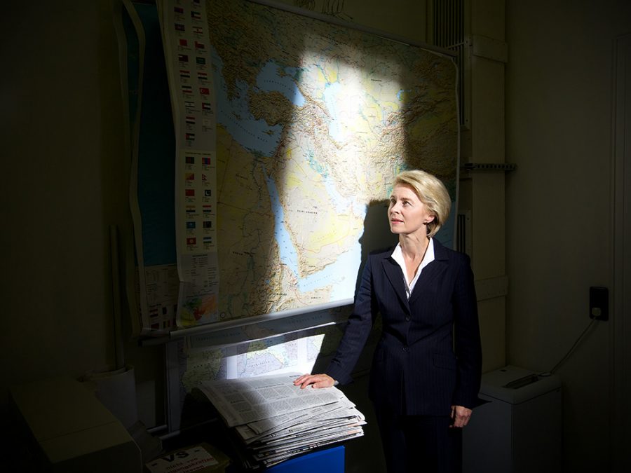 Ursula von der Leyen looking up at a map of the Middle East.