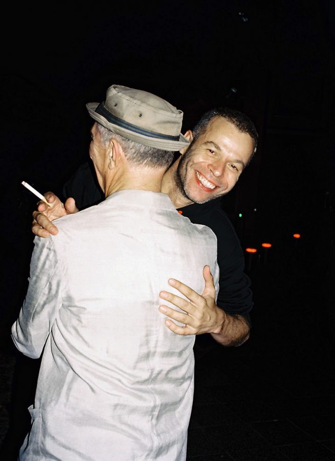 Wolfgang Tillmans hugging a friend while holding a cigarette.