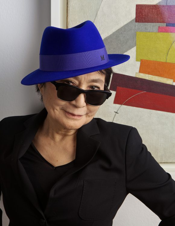 Yoko Ono wearing a blue hat.