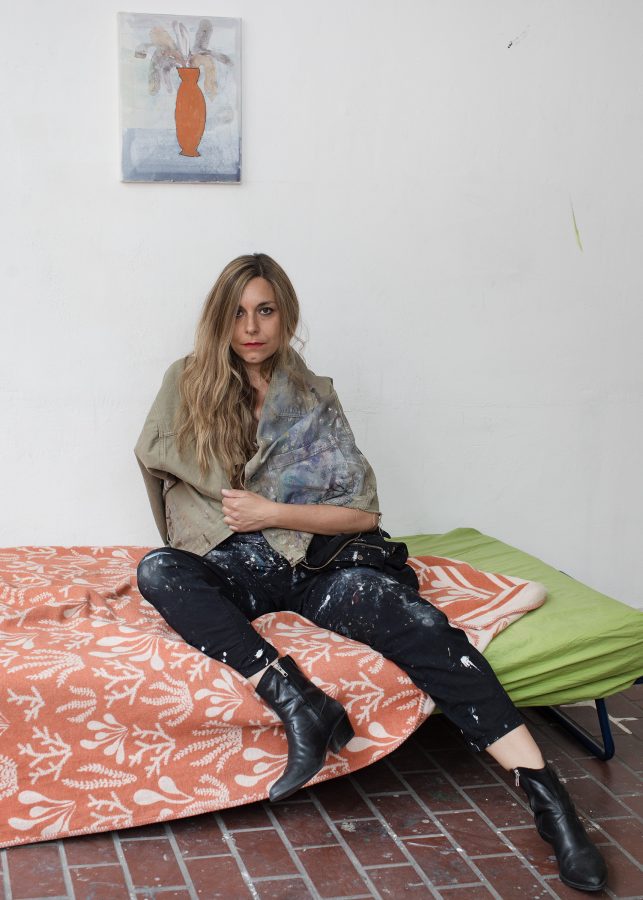 The artist and curator Yvonne Andreini sitting on her studio couch.